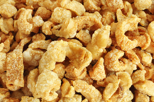 Close up of pork snack or pork scratching at market, crispy fried pork skin and blistered is traditional food in the north of Thailand.