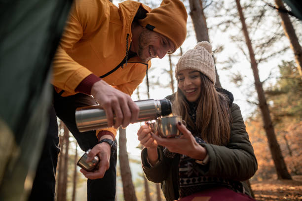 istock Happy couple enjoying in hot drink while camping on mountain 1287609216