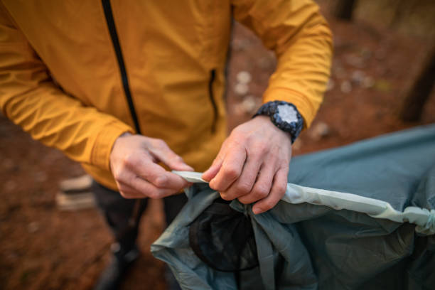 istock Young man setting up tent for camping in forest 1287609375