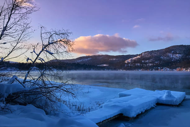 gefrorener berg white lake im winter in den strahlen des sonnenuntergangs. rocky mountains - white lake stock-fotos und bilder