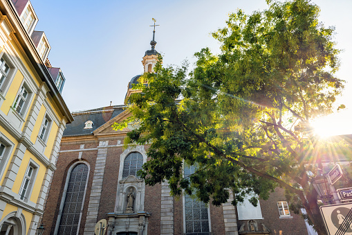 low angle view on brick church and old town house in Düsseldorf city street in the late summer sun