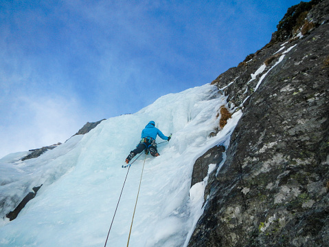 A climber while climbing an ice on a frozen icefall