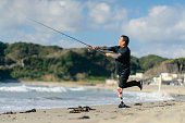 ビーチで人工脚釣りを持つシニア大人の男性