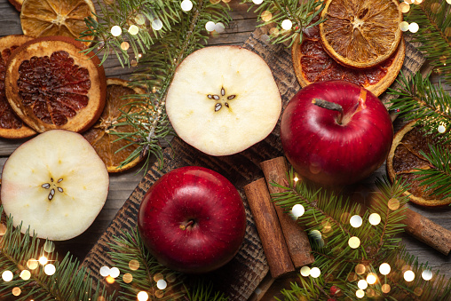 Sliced apples with fried fruit cinnamon and fir tree. Winter holidays festive decorated table treats top view