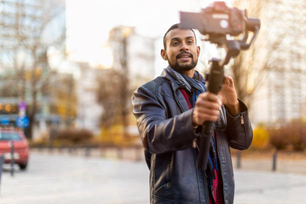 istock Man filming a vlog with camera in the city 1287616967