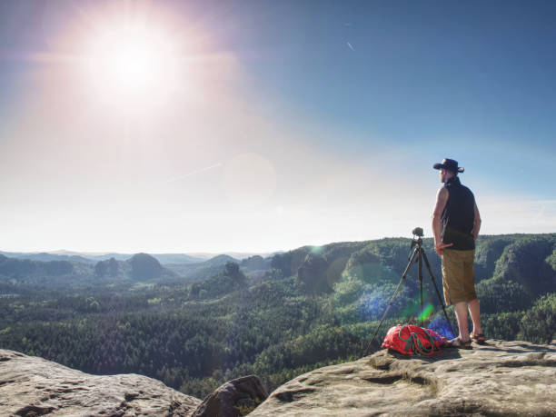 istock Cowboy Hiker At Camera On Tripod, Looking Into Landscape And Thinking. Man With Leather Cowboy Hat 1287617837