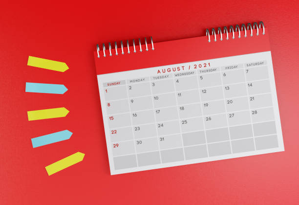 istock August 2021 desk calendar on a red background. With colorful sticky note papers next to it. 1287618492