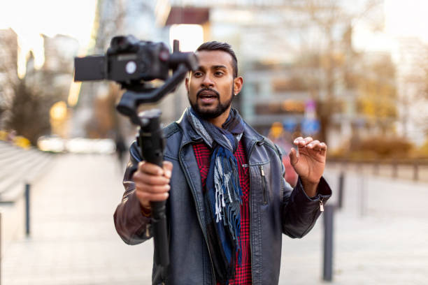 istock Man filming a vlog with camera in the city 1287618842