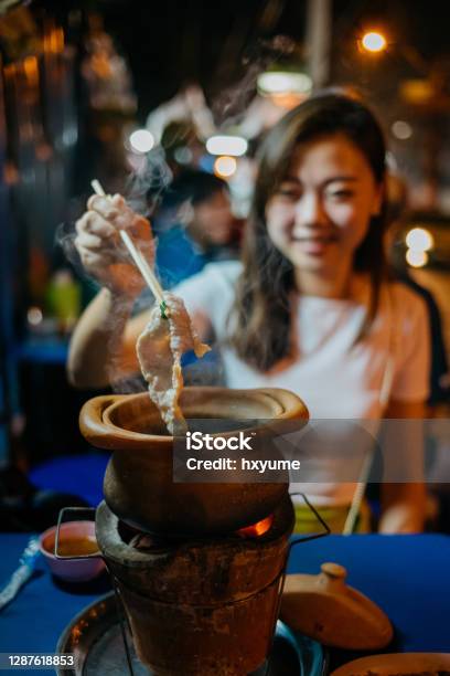 An Asian Chinese Woman Eating Thai Style Jim Jum Hotpot Stock Photo - Download Image Now