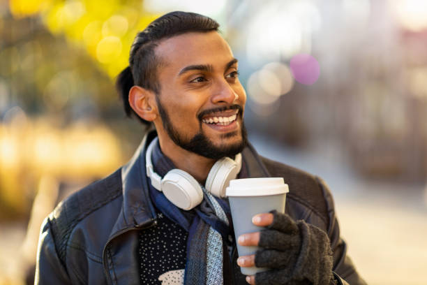 istock Handsome young young man drinking coffee in the street 1287618854