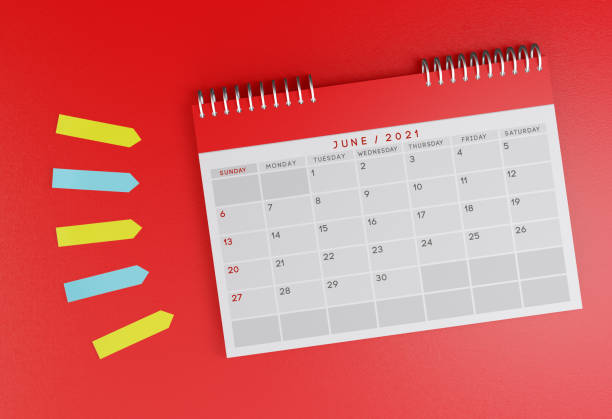 istock June 2021 desk calendar on a red background. With colorful sticky note papers next to it. 1287619648