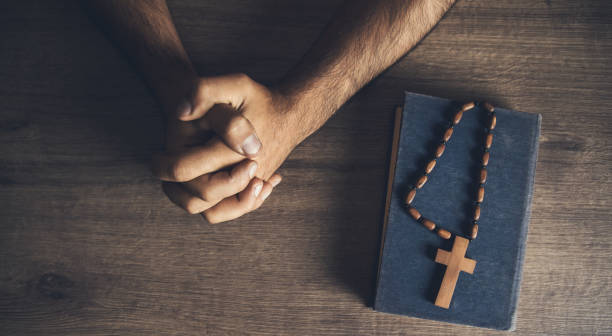 istock prayer man and wooden cross on the Bible 1287619663