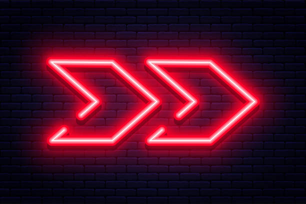 istock Neon arrow sign. Glowing neon arrow pointer on brick wall background. Retro signboard with bright neon tubes 1287621027