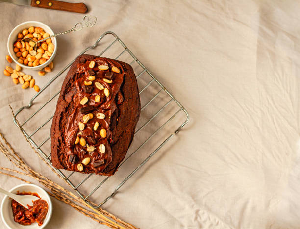 istock Chocolate Brownies cake with nuts and caramel frosting on wire rack on a light linen cloth. Top view. Copy space 1287621144