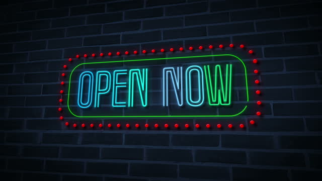 neon open now sign with dots.4k video.motion animation.brick wall background.