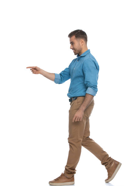 istock young casual man walking and pointing to a side 1287622686