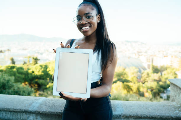 istock Happy woman showing tablet with empty screen to camera 1287622829