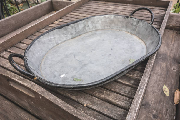istock Metal trough with two handles on wooden planks 1287623558