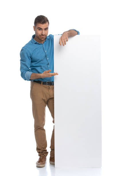 istock sexy casual man presenting and leaning on his long billboard 1287624182