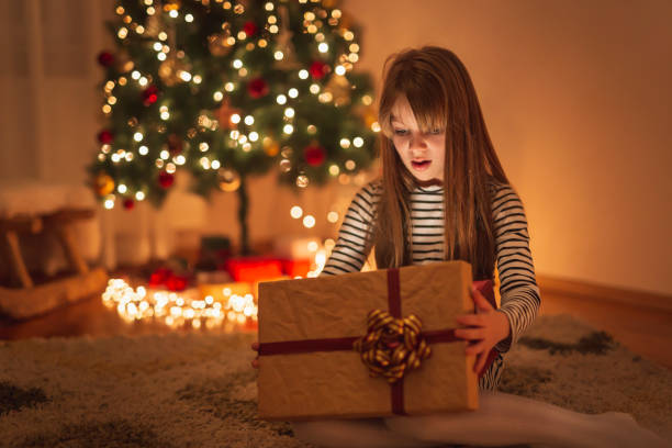 istock Little girl opening illuminated Christmas present 1287625352