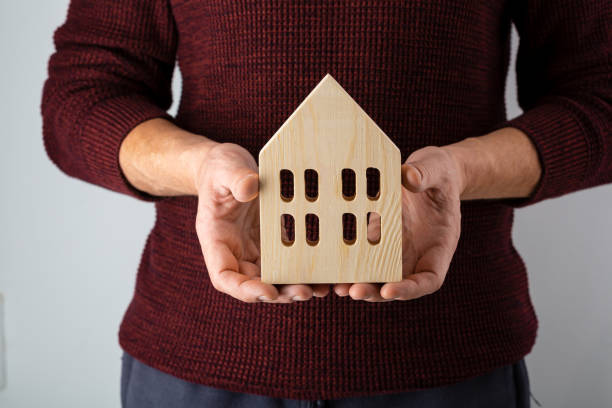 istock Small wooden house in men's hands 1287625860