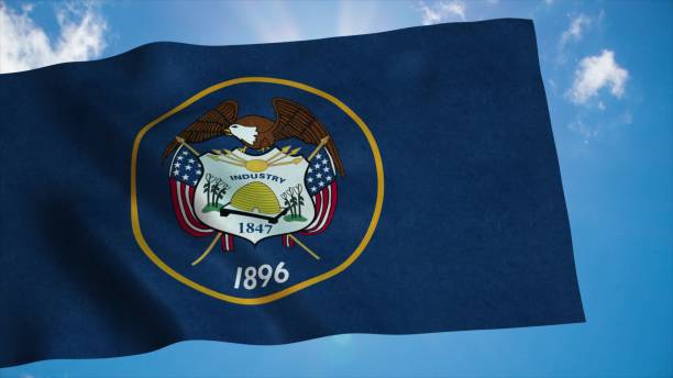 istock Utah flag on a flagpole waving in the wind, blue sky background. 3d rendering 1287628863