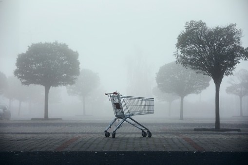 Carrito de la compra abandonado en el estacionamiento en la niebla espesa photo