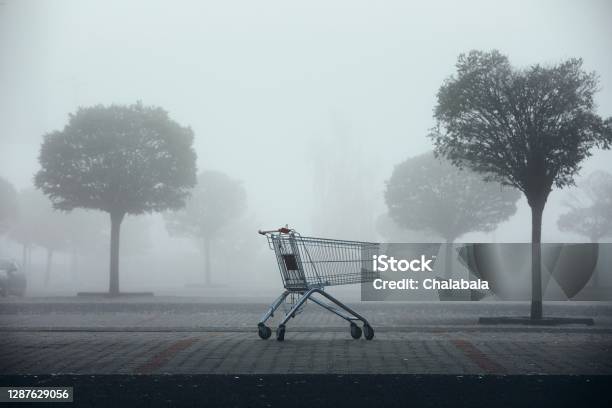 Abandoned Shopping Cart On Parking Lot In Thick Fog Stock Photo - Download Image Now