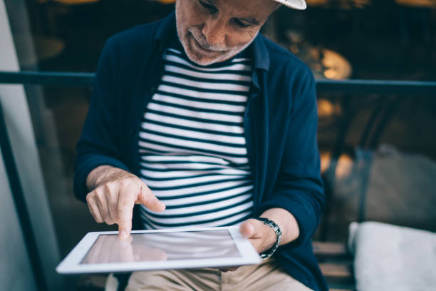 istock Crop aged man browsing tablet near cafe 1287630675