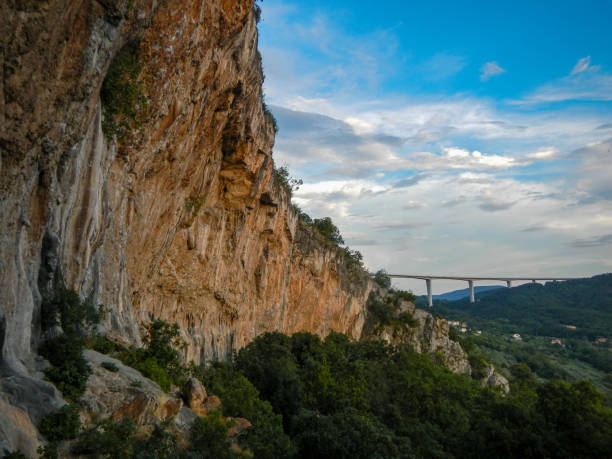 istock Huge rocks in the woods with a visible road bridge 1287631719