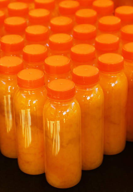 istock Many plastic bottles of fresh orange juice 1287636324