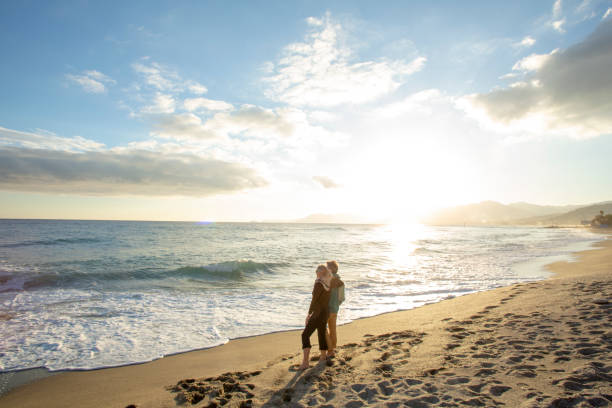istock Mature couple relaxes on sandy beach in the morning 1287636765