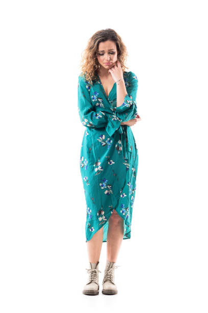 istock Thoughtful sad worried woman in dress looking down with hand on chin having problems. 1287637085