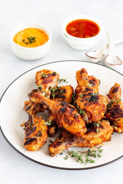 istock Griiled Chicken Drumsticks Garnished with Fresh Thyme and Other Condiments Top Down VerticalPhoto 1287638228