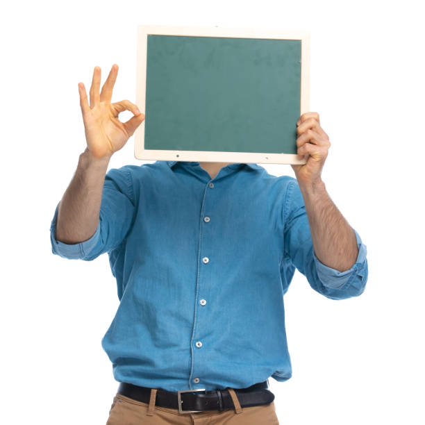 istock casual man hiding behind a board and making 1287638688