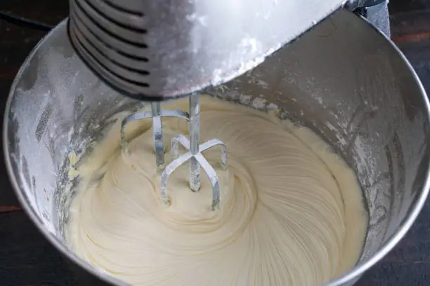 Beating butter, sugar, and vanilla to make white chocolate icing