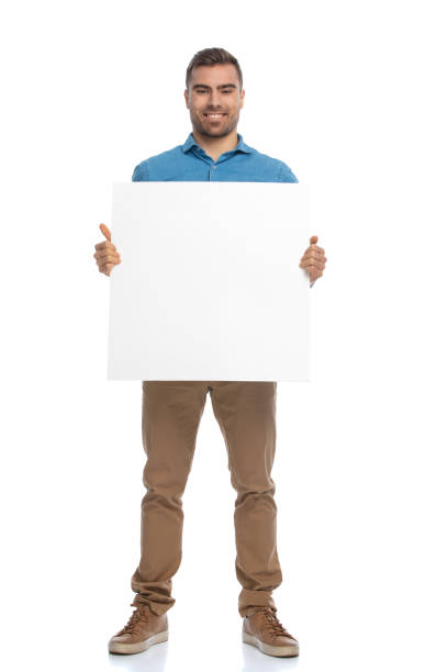istock casual young man holding a blank billboard 1287639999