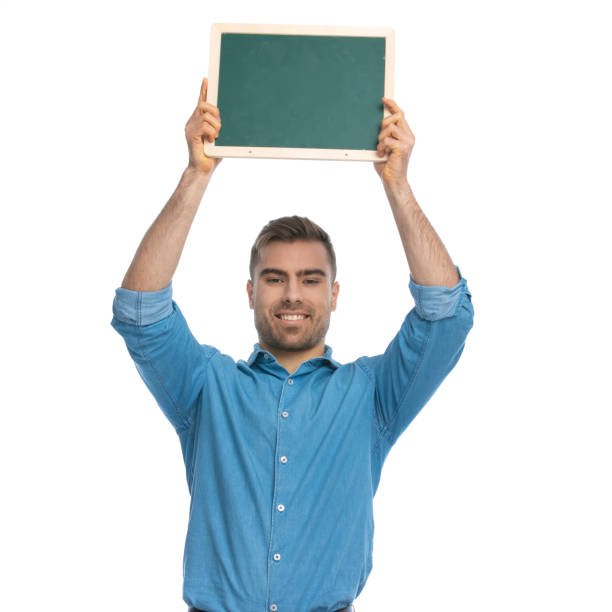 istock young casual man holding a board overhead 1287640209