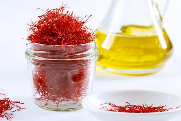 istock Dried saffron threads in a glass bottle and oil extract on a white background. 1287643295