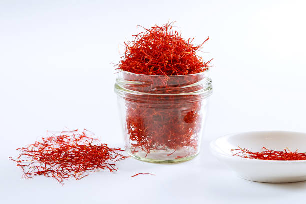 istock Dry saffron threads in a glass jar on a white background 1287643331