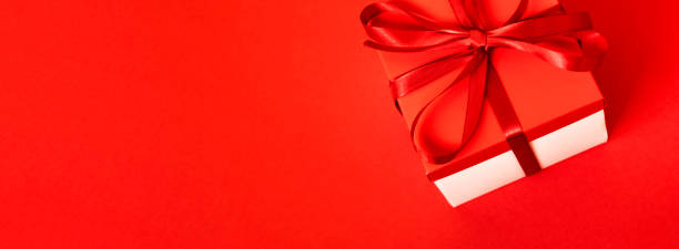 istock Gift box with a cones on a red background. Christmas background. Top view. Space for text. 1287644404