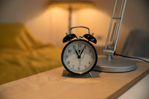 istock Retro alarm clock on wooden table, vintage style 1287648682