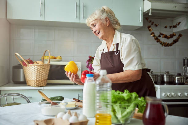 istock Charming old woman cooking dinner in kitchen at home 1287649299