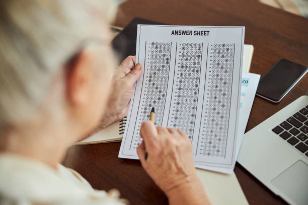 istock Senior woman checking answers for test at home 1287649319