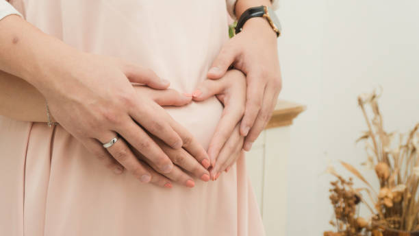 istock Couple make heart shaped hand on pregnant belly 1287650961