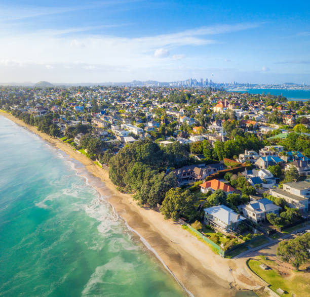 Beach properties in Auckland A high angle view perspective of beachfront properties and suburbs in Auckland's Takapuna district, with the Sky Tower and the downtown cityscape on the horizon. auckland stock pictures, royalty-free photos & images