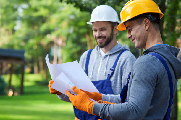 discutiendo ideas. retrato de dos constructores positivos de pie al aire libre con un plano abierto que discute la casa de campo medio terminado - construction worker architect construction manual worker fotografías e imágenes de stock