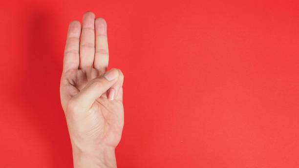 istock A hand sign of 3 fingers point upward meaning three, third or use in protest.It put on red background 1287654351