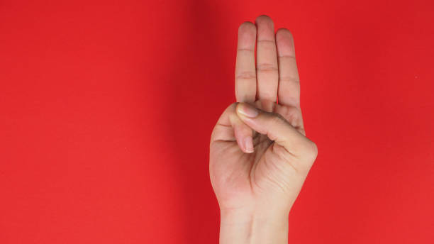 istock A hand sign of 3 fingers point upward meaning three, third or use in protest.It put on red background 1287654383