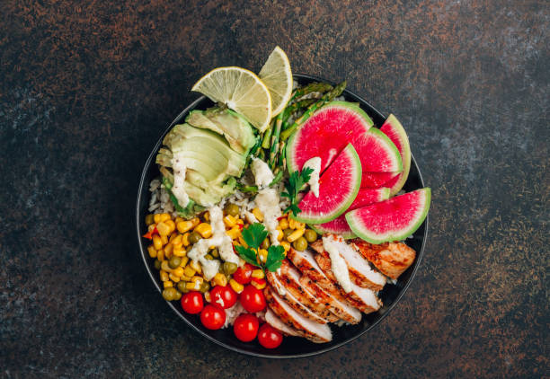 istock Buddha bowl with brown rice, grilled chicken breast, avocado, tomato, peas, corn, radish 1287654420